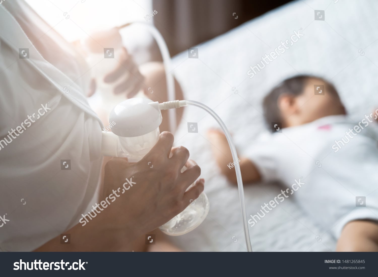 stock-photo-asian-pretty-mother-pumping-breast-milk-on-the-bed-in-bedroom-the-baby-lying-and-sleeping-on-the-1481265845